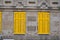 yellow closed shutters on grey building