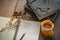 Yellow coffee cup on the desk with books. Notebook and pencil placed on a sunny morning.