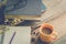 Yellow coffee cup on the desk with books. Notebook and pencil placed on a sunny morning.