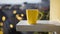 A yellow coffee mug sits on a white bench