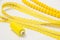 Yellow coil with threads and beads on a white background