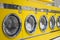 Yellow coin washing machines with laundry in it