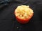 Yellow color Jaggery Slices or cut Pieces in a sand Plastic bowl and Plastic cup isolated on black background