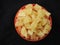 Yellow color Jaggery Slices or cut Pieces in a sand Plastic bowl and Plastic cup isolated on black background