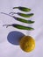 Yellow coloured lemon on white background with chillies.