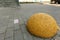 Yellow concrete hemisphere prohibiting parking barrier. Concrete limiter on road from granite pavers