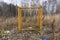 Yellow concrete pillar with a warning sign Gas, outdoors in the grass. Gas pipes, valves and devices for a gas pumping station Gas