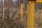 Yellow concrete pillar with a warning sign Gas, outdoors in the grass. Gas pipes, valves and devices for a gas pumping station Gas