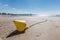 Yellow conical buoy on the beach at low tide