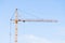 Yellow construction crane on a blue sky background. space for copying text