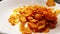 Yellow cornflakes are thrown into a bowl with milk in close up and slow motion