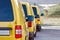 Yellow courier or taxi cars are lined up in parking lot.