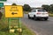 Yellow Covid 19 Test Centre road sign at the side of highway with direction arrow to entrance