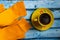 Yellow cozy knitted sweater with a cup of coffee on a blue wooden table, flat lay