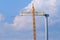 Yellow crane tower placing windmill blade with background of blue sky