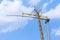 Yellow crane tower placing windmill blade with background of blue sky. Wind Turbine Construction