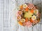 Yellow cream cake decorated with buttercream flowers - peonies, roses, chrysanthemums, scabiosa, carnations - on white wooden back