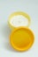Yellow cream jar on white background.
