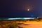 Yellow crescent moon above a stunning beach