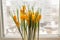 Yellow crocuses in plastic pot on window sill. Spring flowers, domestic gardening