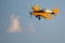 Yellow Crop Dusting Plane Flying in a Blue Sky