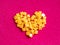 Yellow crystal craft handmade heart shape for diamond embroidery hobby rhinestone. Background with bright leather texture. Pink