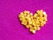Yellow crystal craft handmade heart shape for diamond embroidery hobby rhinestone. Background with bright leather texture. Pink