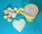 Yellow cup with cappuccino, heart made of sugar and seashells on a blue background