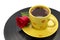 Yellow cup of coffee with beautiful red rose on record