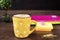 Yellow cup of coffee with white dots. Pretty pink office accessories - notebooks, gold pins, stickers, rubber and polka dot mug