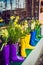 Yellow daffodils and hyacinth in multicolored rubber boots used as pots decorating the storefront window. Selective focus