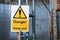 Yellow Danger Keep Out sign on metal fence