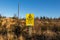 Yellow danger sign warning of overhead electrical power lines and risk of death