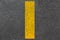 Yellow dashed line of road markings close-up on the new bituminous asphalt road.