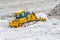 Yellow Deere 750J bulldozer shovels heaps of snow. Russia, Saint-Petersburg. 19 february 2019