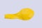 Yellow deflated balloon on white background.