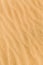 Yellow desert sand with diagonal wave patern.