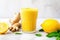 yellow detox smoothie with a lemon slice by the side