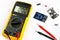 Yellow digital multimeter electronic measurement device tool with red and black cables microc chip circuit board led and micro