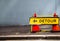 Yellow Direction sign for detour on the footpath.