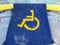 Yellow disabled-person sign marking a space at a parking lot, on a blue background