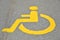 Yellow disabled sign on the asphalt of the street