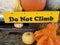 Yellow do not climb sign near orange pumpkins