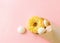 Yellow donat and white meringue cookies in a paper envelope on a beige background