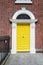 A yellow door in Dublin, Ireland. Arched Georgian door house front