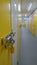 A yellow door at the end of a self storage unit corridor
