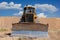 Yellow dozer on a dirt terrain with blue sky