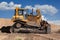 Yellow dozer on a dirt terrain with blue sky