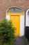 Yellow Dublin door over brick wall