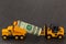 Yellow dump truck carrying dollar money sending to forklift on b